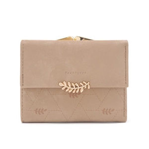 Detail of vintage matte leather wallet with golden leaf clasp and geometric stitching