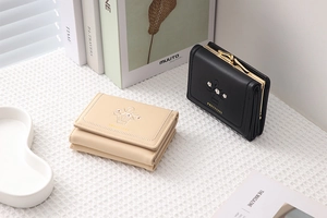 Detail of beige and black PU leather tri-fold wallets with floral daisy embroidery