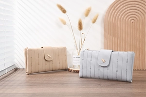 Close-up of PU leather long wallets with leaf buckle and elegant striped texture