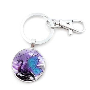 Close-up of a round silver keychain with a mystical purple dragon illustration and lobster clasp