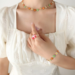 Colorful floral enamel daisy necklace and bracelet set worn by a fashion model