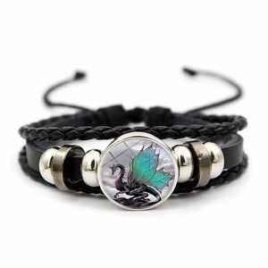 Detail of woven leather bracelet with a green dragon glass gem and adjustable cord