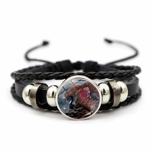 Macro shot of adjustable braided bracelet with red dragon glass charm and silver beads