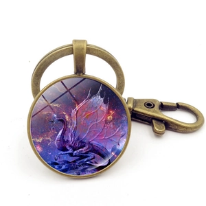 Detailed close-up of a bronze dragon glass gem keychain with a purple nebula background