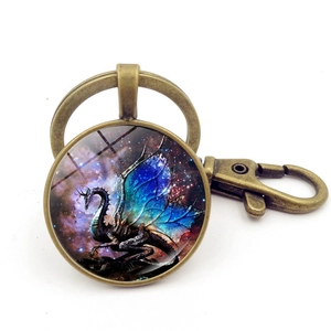 Macro shot of bronze dragon keychain with blue winged dragon glass gem and lobster clasp