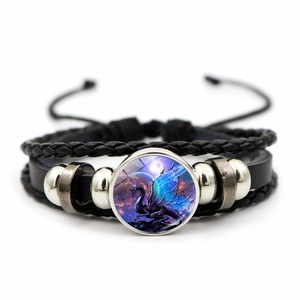Detail of woven leather bracelet featuring a blue dragon glass cabochon and metal beads