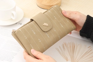 Detail view of khaki PU leather long wallet featuring leaf embroidery and snap closure