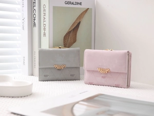 Close-up of trifold frosted leather wallets with metal leaf buckle and snap closure