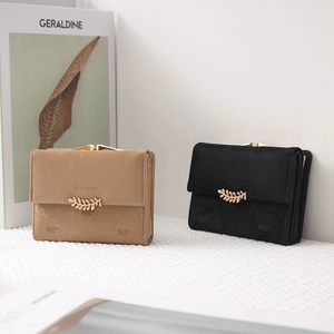 Close-up of matte leather wallets with geometric patterns and leaf-shaped metal clasps