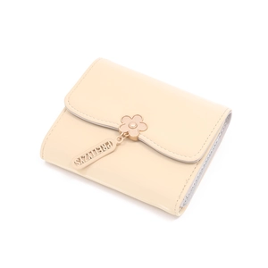 Detail of beige tri-fold wallet with flower pendant and matte faux leather texture