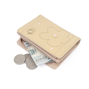Detail of short tri-fold beige PU wallet showing floral embroidery and cash storage