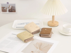 Detailed view of floral embossed PU leather wallets in soft beige, yellow and coffee tones