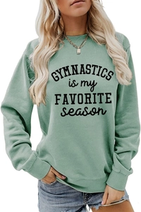 Close-up of sage green gymnastics sweatshirt with black printed text on soft fabric