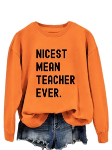 Detail view of orange sweatshirt with black text print and distressed denim shorts texture