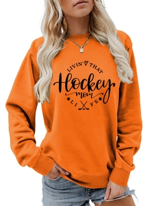 Close-up of bright orange sweatshirt with hockey mom text print and ribbed cuffs