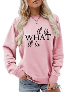 Detail eines rosa Sweatshirts mit schwarzem 'it is what it is' Spruch und Rippbündchen