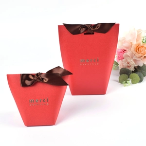Scatole regalo trapezoidali rosse con scritta Merci dorata e nastri di raso