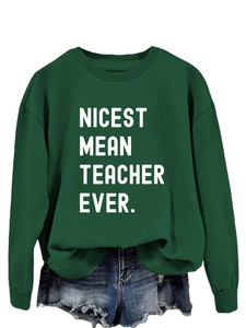 Close-up of dark green sweatshirt with Nicest Mean Teacher Ever print on white background