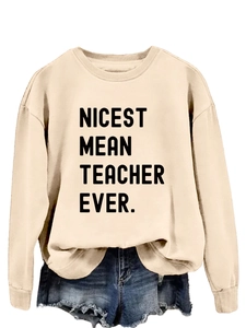 Detail of Nicest Mean Teacher Ever beige sweatshirt with ribbed cuffs and blue denim shorts