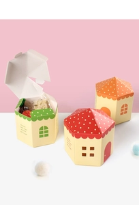 Dettagli di scatole regalo colorate a forma di casa con tetti a pois e motivi a finestre