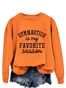 Detail view of bright orange sweatshirt with Gymnastics is my Favorite Season lettering