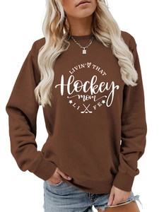 Detail of hockey mom life graphic on dark brown crewneck sweatshirt with ribbed cuffs