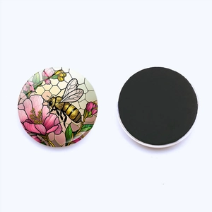 Detail of 25mm round glass fridge magnet showing stained glass bee and flower design