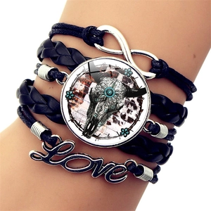 Dettaglio del bracciale multistrato in pelle con ciondolo teschio di toro e charm Love