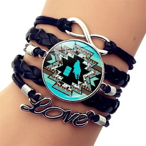 Dettaglio del bracciale in pelle multistrato con ciondolo infinito e silhouette equestre