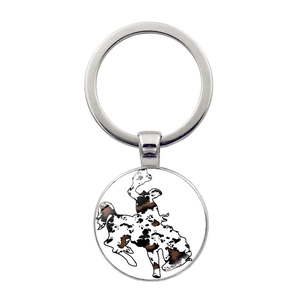 Silberner Schlüsselanhänger mit Cowboy-Silhouette und Kuhmuster auf rundem Anhänger