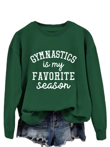 Close-up of gymnastics letter print on deep green long sleeve crewneck sweatshirt