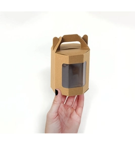Dettaglio della scatola regalo esagonale in carta kraft con finestra e manico pratico