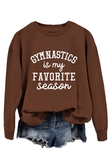 Close-up of brown sweatshirt with Gymnastics is my favorite season white slogan