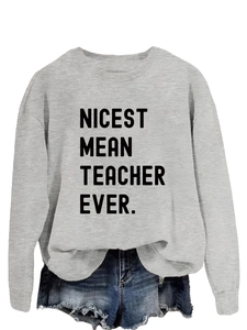Detail view of the black NICEST MEAN TEACHER EVER lettering on a grey sweatshirt