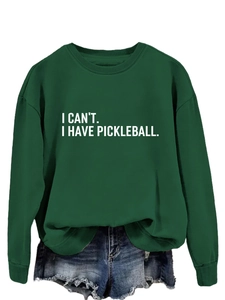 Detail eines grünen Pickleball-Sweatshirts mit weißem Schriftzug und Denim-Shorts
