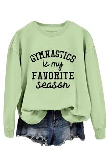 Close-up of light green gymnastics sweatshirt with black typography on white background