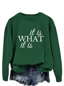 Detailaufnahme des weißen 'it is WHAT it is' Schriftzugs auf dem dunkelgrünen Sweatshirt