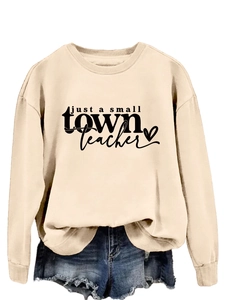 Détail de l'imprimé Just a Small Town Teacher sur le sweat à col rond de couleur beige