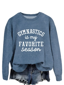 Detailed view of gymnastics slogan print on blue long-sleeve sweatshirt fabric texture