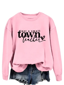 Détail à plat du sweat rose avec message d'enseignant et short en jean bleu