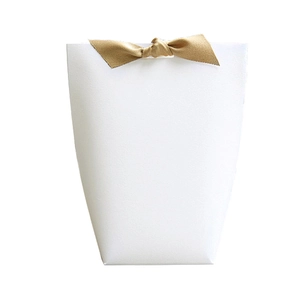Elegant white trapezoid gift box with a gold ribbon bow for jewelry and cosmetics