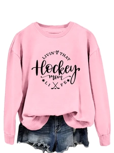 Detail of pink crewneck sweatshirt with 'Hockey Mom' print and heart graphics