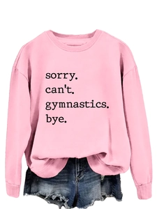Close-up of pink crewneck sweatshirt with 'sorry can't gymnastics bye' printed text