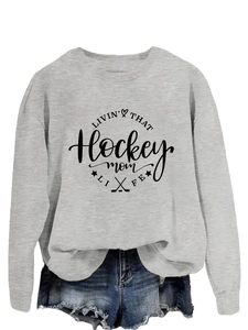 Detail of hockey mom life graphic print on grey crewneck sweatshirt with heart and sticks