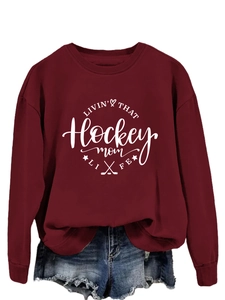 Close-up of wine red sweatshirt featuring Hockey Mom print and crew neck detail