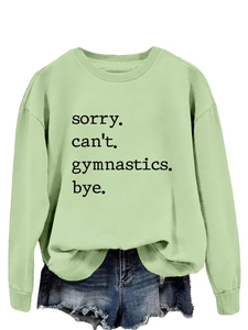Close-up of sorry can't gymnastics bye slogan on light green long sleeve sweatshirt