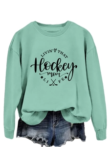 Detail of mint green sweatshirt featuring ribbed cuffs and Hockey Mom graphic print