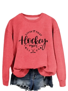 Close-up of the Hockey Mom Life print on a coral pink long sleeve crewneck sweatshirt
