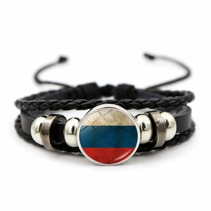 Detail view of multi-layer leather bracelet featuring a Russian flag glass cabochon charm
