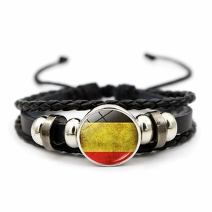 Close-up of multilayer braided leather bracelet with flag glass cabochon charm